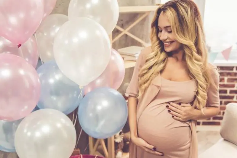 woman-standing-next-to-blue-white-pink-balloons